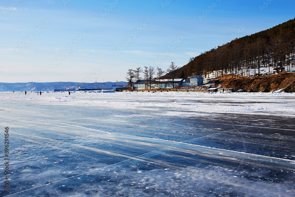 Beautiful landscape of frozen Lake Baikal. Listvyanka village in winter sunny frosty winter day.