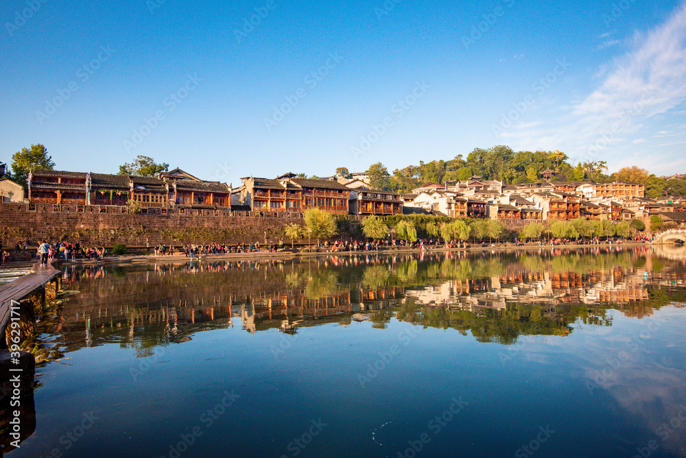 the river, the boat, stone bridge and the old houses at ancient phoenix town in the morning at Hunan, China.
