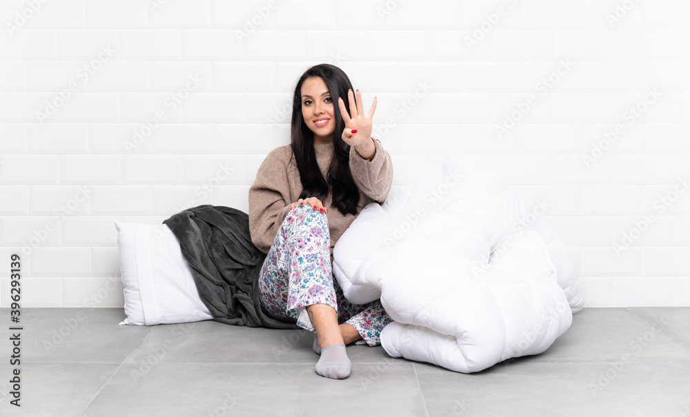 Young Colombian girl in pajamas at indoors happy and counting four with fingers Young Colombian girl in pajamas at indoors happy and counting four with fingers