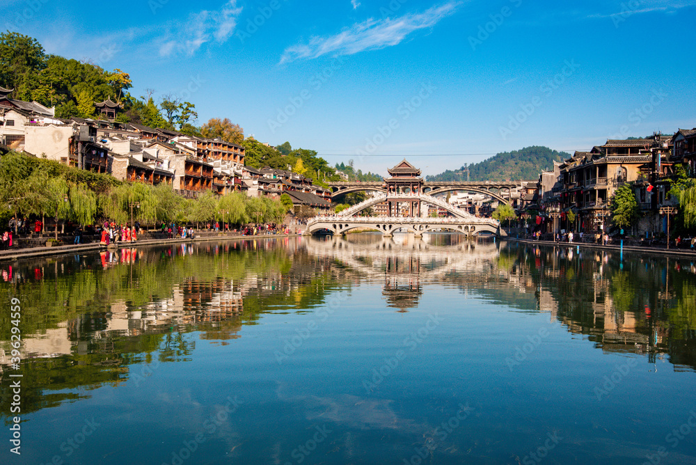 the river, the boat, stone bridge and the old houses at ancient phoenix town in the morning at Hunan, China.
