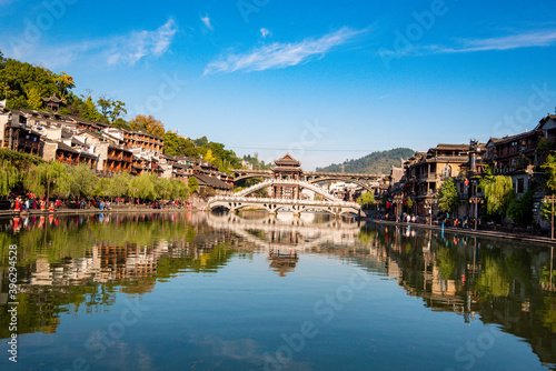 the river  the boat  stone bridge and the old houses at ancient phoenix town in the morning at Hunan  China. 