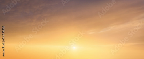 background of cloudscape at the sunset with sunshine on bright sky and orange clouds
