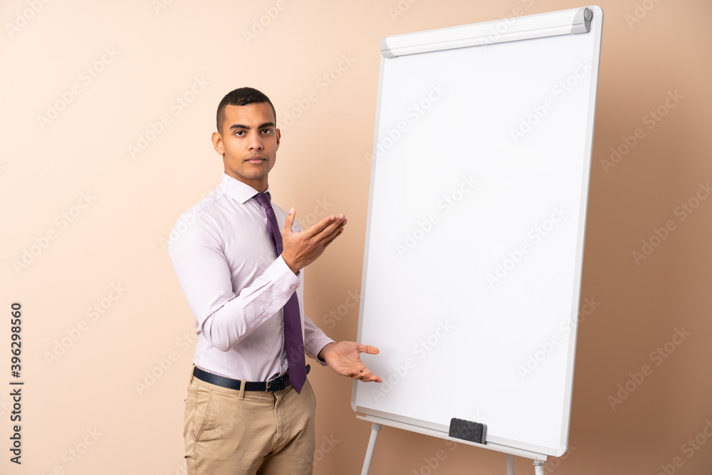 Young business man over isolated background giving a presentation on white board Young business man over isolated background giving a presentation on white board