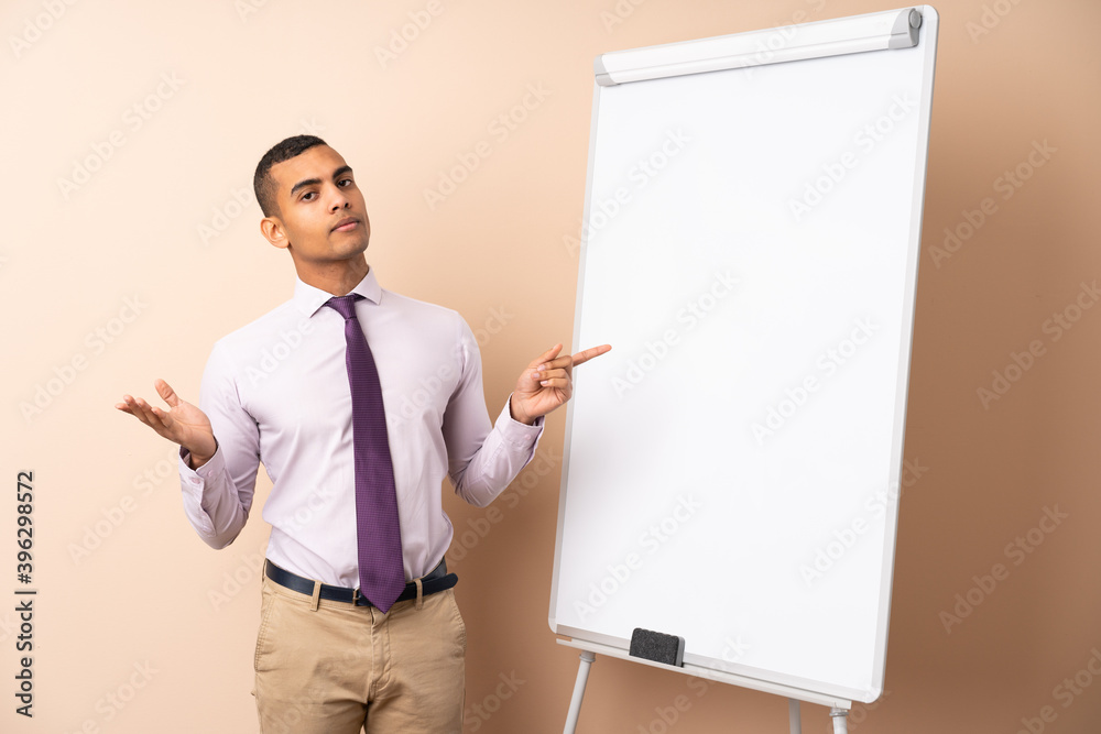Young business man over isolated background giving a presentation on white board Young business man over isolated background giving a presentation on white board