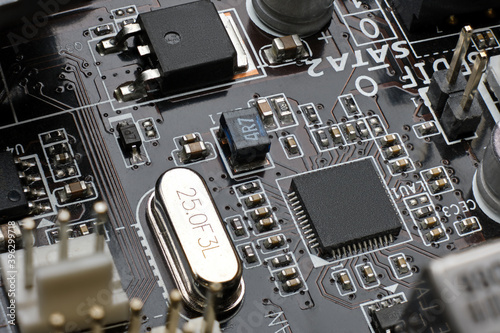 Smd chip ethernet microcontroller on brown motherboard with a lot of surface mount components resistors, capasitors, transistors, crystal oscilator, inductor and plugs.