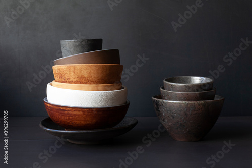 Tela Still life with handmade ceramic dishware on a black background