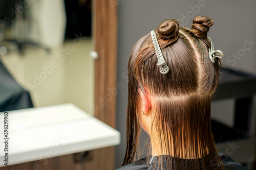 Divided women's hair into sections with clips in the barbershop photo