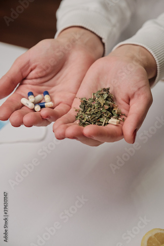 Medicine pills or herbs concept. Natural herbs. Two hands as a scale. Pandemic problem