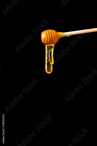 Honey flows from a spoon on a black background.