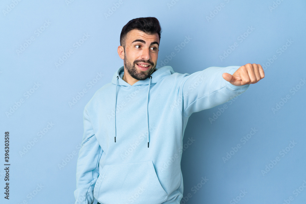 Caucasian man over isolated blue background giving a thumbs up gesture Caucasian man over isolated blue background giving a thumbs up gesture