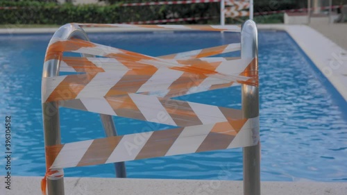 Closed slide in public swimming pool during coronavirus pandemic, caution tape, lockdown public space