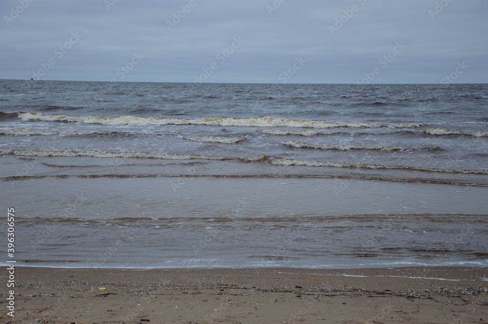 Grey sky over Baltic sea on a cold spring day with small waves and a clear horizon