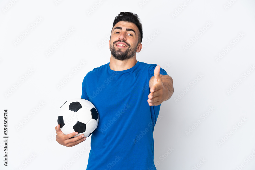 Handsome young football player man over isolated wall shaking hands for closing a good deal Handsome young football player man over isolated wall shaking hands for closing a good deal