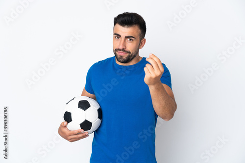 Handsome young football player man over isolated wall making money gesture