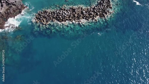 Aerial Drone shot to reveal a view of a beautiful sandy beach, people swimming. Drone shot flying over Abama Beach, Santa Cruz de Tenerife at the Canary Islands photo