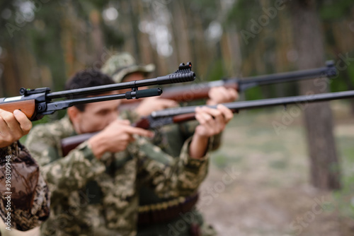 Concentrated Hunters Aiming with Rifles Bird Hunt.