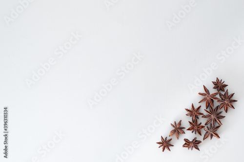 star anise brown with asterisks on a white flat background is located in the corner below. spices for mulled wine © Elena
