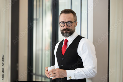 Bearded hipster businessman holding coffee cup portraits.