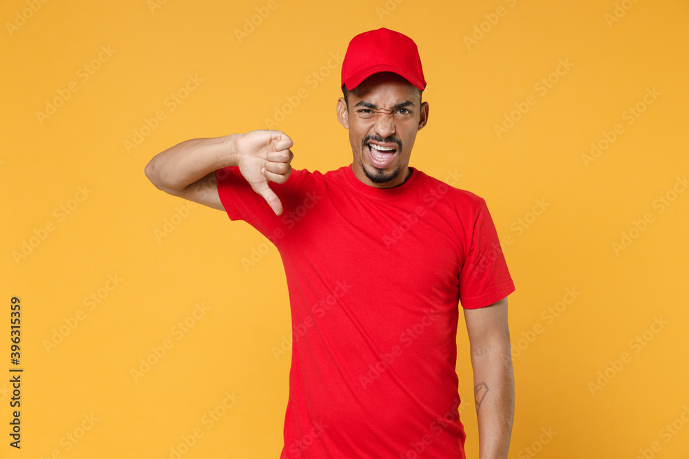 Delivery employee african man 20s in red cap blank print t-shirt uniform workwear work courier dealer service during quarantine coronavirus covid-19 virus concept isolated on yellow background studio.