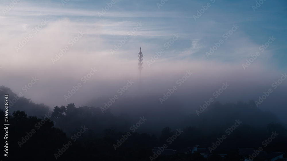 Early morning sunrise with thicker fog or mists over a 5G comm tower