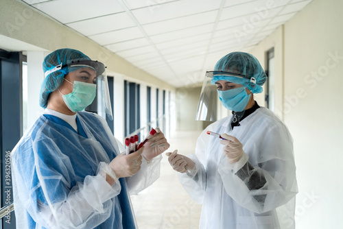 two nurses work with blood samples to determine the outcome of a coronavirus infection
