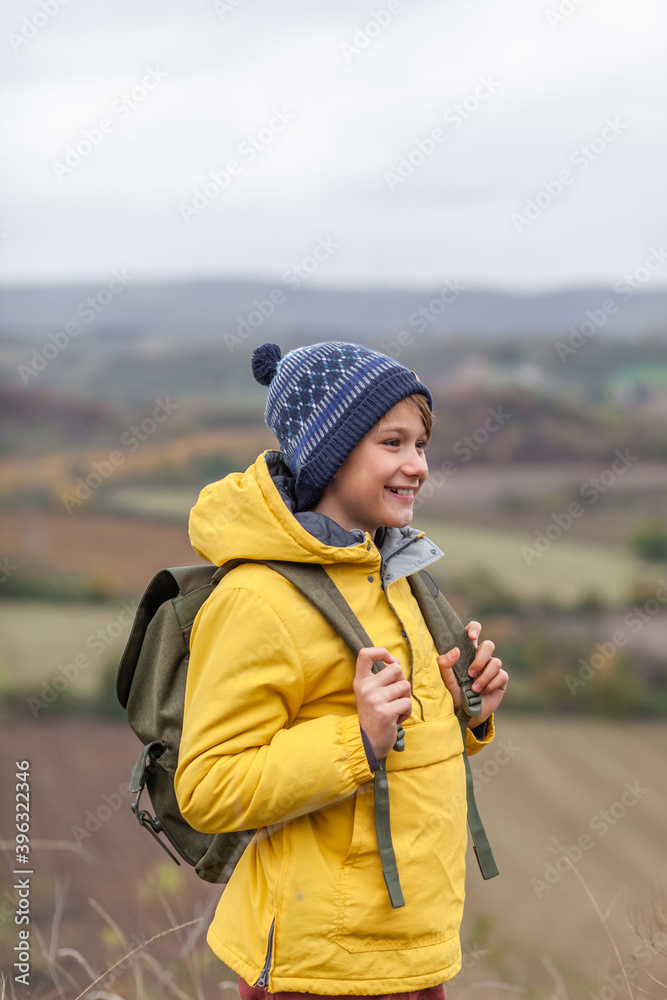 Happy little hiker during autumn day on a hill.