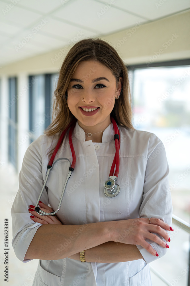 Portrait of beautiful smiling nurse in white uniform with stethoscope looking at camera Portrait of beautiful smiling nurse in white uniform with stethoscope looking at camera