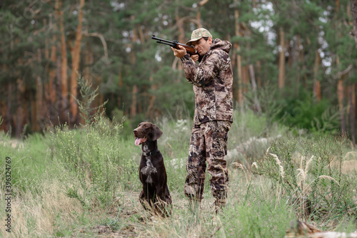 Man Aiming with Rifle Hunt in Summer Forest. photo