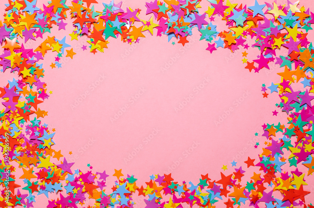 Flat lay frame background of multicolored sparkle confetti glittering shine stars isolated on pink. Top view. For Christmas, holiday, festive, sales. Flat lay frame background of multicolored sparkle confetti glittering shine stars isolated on pink. Top view. For Christmas, holiday, festive, sales.