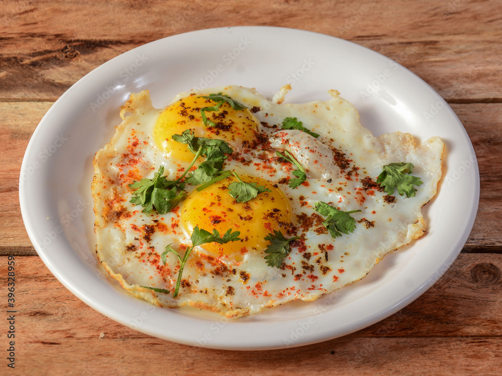 Indian style tasty and healthy double egg half fried omelet on a wooden rustic background. selective focus Indian style tasty and healthy double egg half fried omelet on a wooden rustic background. selective focus