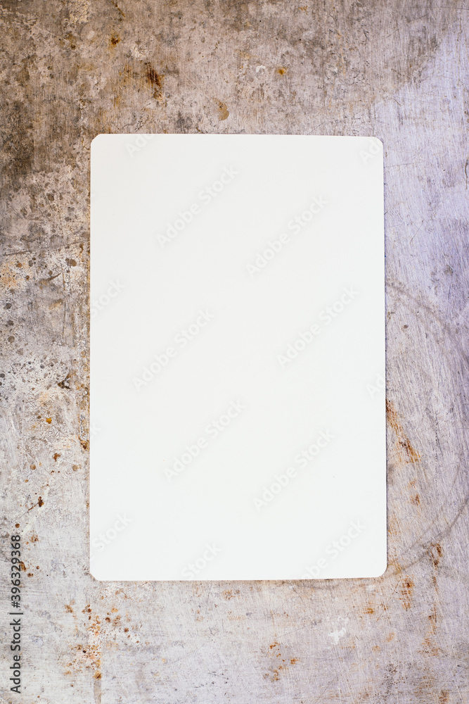 Blank piece of paper on metal surface Blank piece of paper on metal surface
