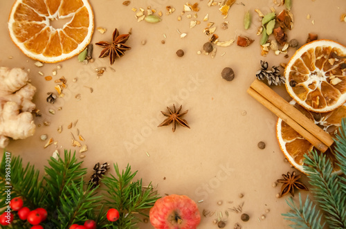 Winter composition with copy space. Star anise, spruce branch, rowan, dried orange, apple, spices, ginger, cinnamon stick with copy space. Top view, flat lay.