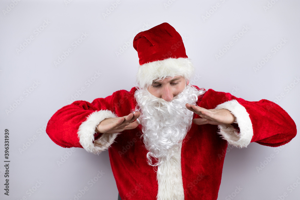 Man dressed as Santa Claus standing over isolated white background shouting and screaming loud down with hands on mouth