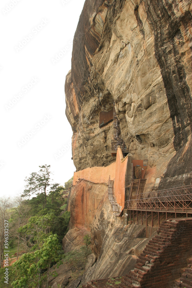 Sigiriya Rock Sri Lanka with walkway along cliff face and stairs rock paintings