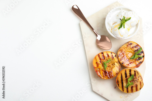 Delicious grilled peaches with ice cream and honey on white table, top view. Space for text