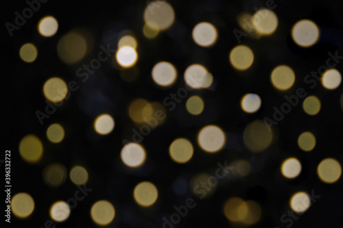 Golden particles bokeh and lens flare on dark background
