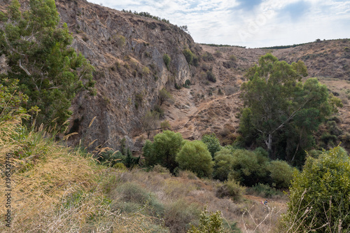 Hills overgrown with greenery near the HaTanur waterfall, which is located in the continuation of the rapid, shallow, cold mountain Ayun river in the Galilee in northern Israel