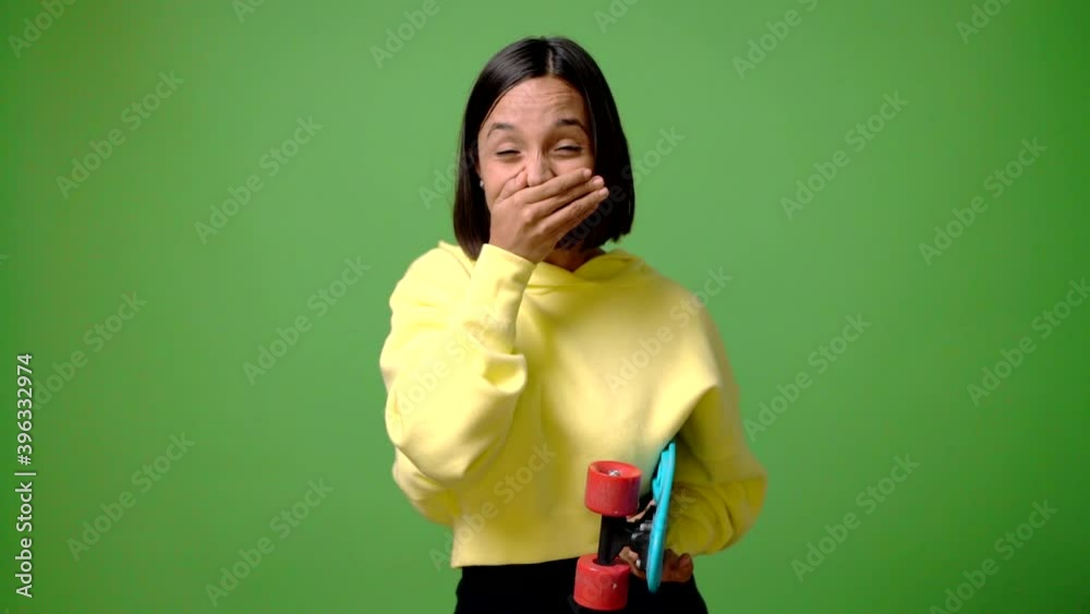 Young skater woman on green screen chroma key background with surprise and shocked facial expression Young skater woman on green screen chroma key background with surprise and shocked facial expression