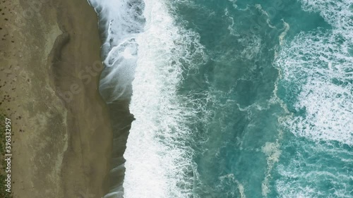 Vista aera di un'onda che si infrange sulla spiaggia sabbiosa. photo