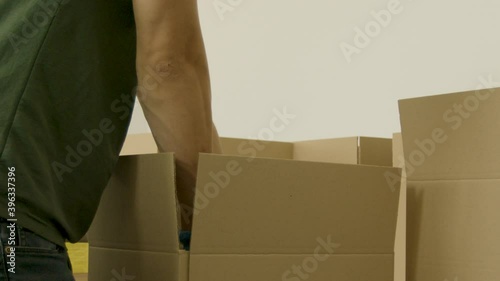 Person putting cans into a blank cardboard box for a food bank slow motion