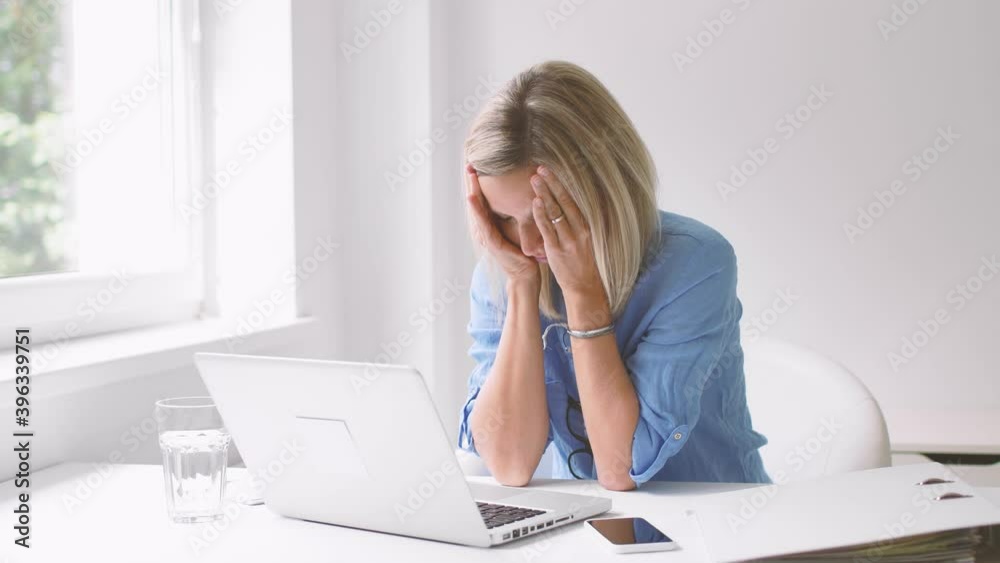 Overworked businesswoman falling asleep in front of laptop Overworked businesswoman falling asleep in front of laptop