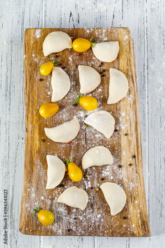 Raw dumplings, frozen homemade dumplings, on a wooden Board Raw dumplings, frozen homemade dumplings, on a wooden Board