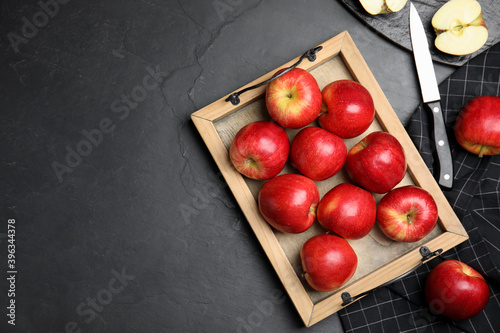 Fresh ripe red apples on black table, flat lay. Space for text