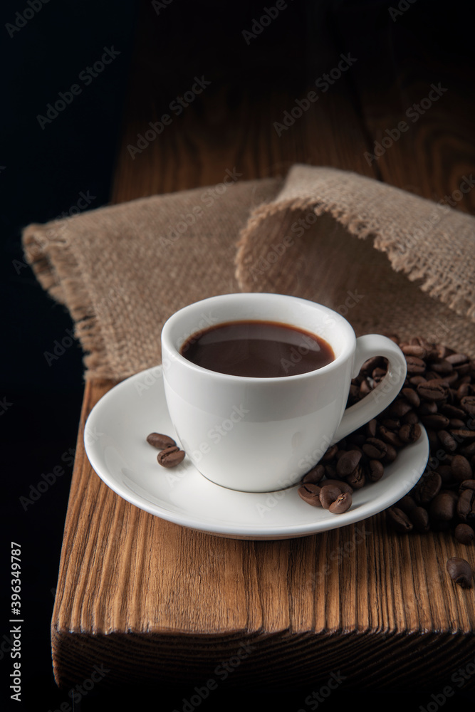 White cup with espresso and coffee beans on wooden table White cup with espresso and coffee beans on wooden table