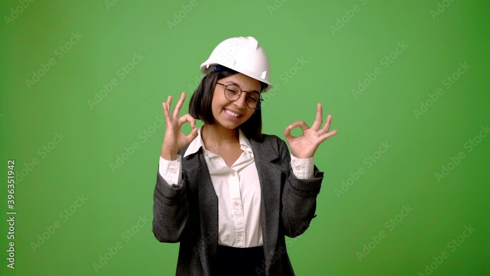 Young architect woman on green screen chroma key background showing ok sign with fingers Young architect woman on green screen chroma key background showing ok sign with fingers