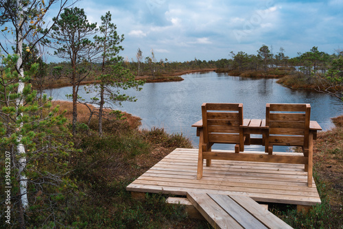 Top view of two wooden chairs by the lake of the Kemeri National Park © Nikolajs Selusenkovs