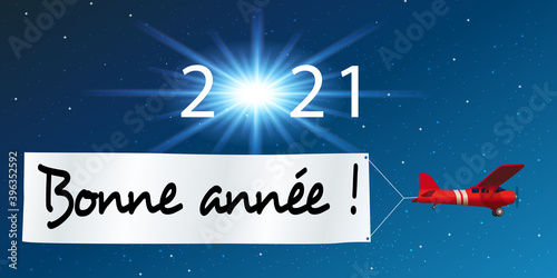 Carte de vœux 2021 montrant un avion rouge tirant une banderole blanche pour souhaiter la bonne année, devant un ciel étoilé.