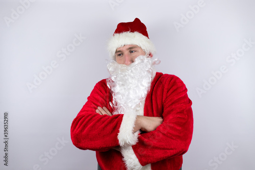 Man dressed as Santa Claus standing over isolated white background thinking looking tired and bored with crossed arms