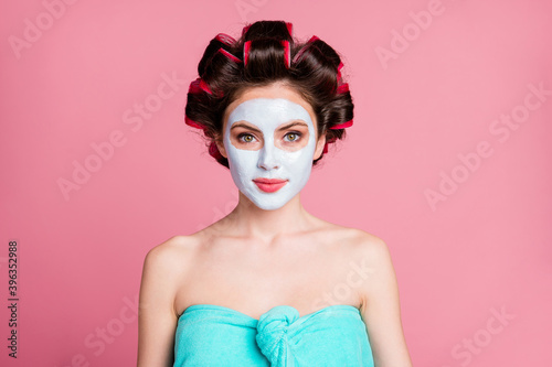 Close-up portrait of nice content housewife applying wearing blue white clay mask rejuvenation isolated over pink color background