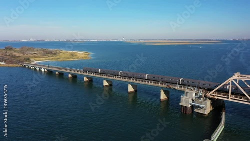 Wallpaper Mural A high angle shot of a NYC subway train crossing over the bay in Queens, NY. The camera trucks left following the train. The sun is shining and it is a beautiful day. Torontodigital.ca